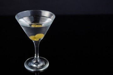 Cocktail martini with olives on table