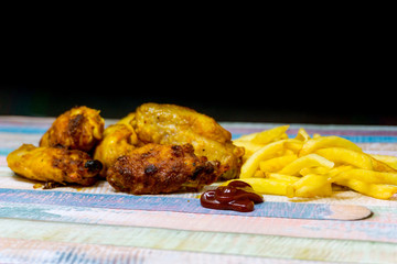 Chicken wings with sauce and golden French fries potatoes