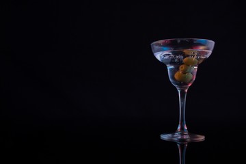 Cocktail martini with olives on table