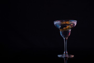 Cocktail martini with olives on table