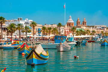 Naklejka premium Tradycyjne eyed kolorowe łodzie Luzzu w porcie śródziemnomorskiej wioski rybackiej Marsaxlokk, Malta
