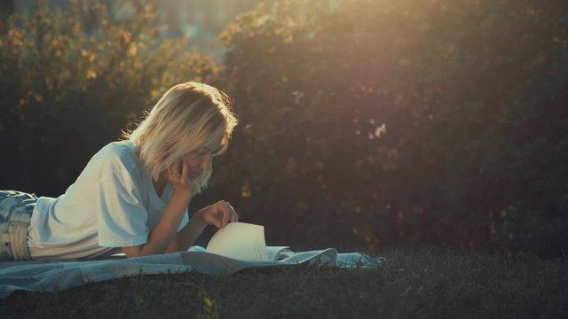 Young girl reading a book in the park