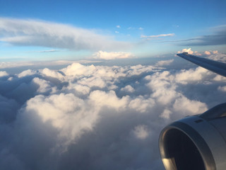 Sky above the cloud from the plane's window with the plane's wing