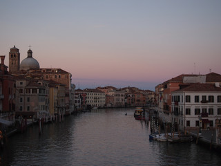 Fototapeta na wymiar the grand canal in venice in evening twilight with sunset sky and street lights coming on with reflections or historic buildings and boats
