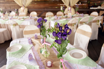 Beautifully decorated table for the wedding ceremony. Served banquet table decorated with fresh flowers in the open air
