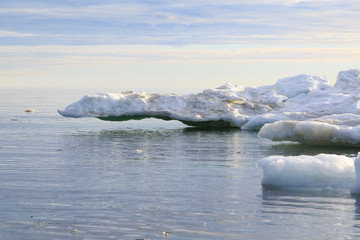 Ice in sea water against sky horizon