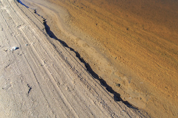 Sandy coastal strip with sharply outlined shade