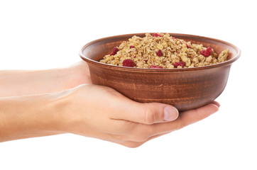 homemade granola with dried fruits in ceramic jar in hand isolated on white background