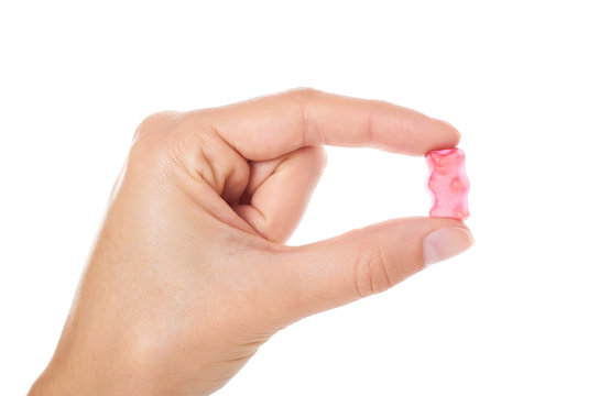 Childhood and jelly bears candies in hand isolated on white background