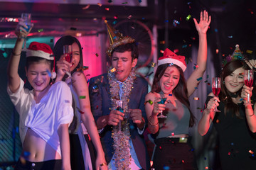 Young people dancing and showered with confetti on a club party on Friday night