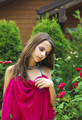 A young charming girl on summer vacation on the background of a bungalow in a warm country