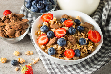 Healthy breakfast concept with oat flakes and fresh berries on rustic background. Food made of granola, muesli. Healthy banana smoothie with blackberries, muslie, strawberries, blueberries and honey.