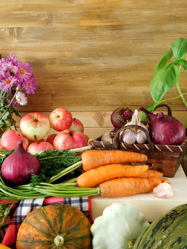 Freshly picked harvest of different autumn vegetables and fruit on a wooden background. Autumn harvest. Copy space