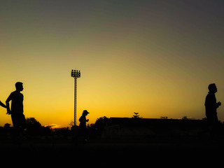 Silhouette teen age run together  track.