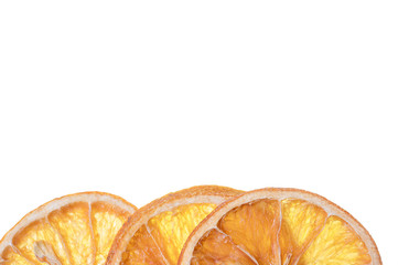 Three slices of dried orange placed on bottom edge on white background
