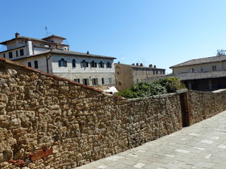Strada con un muro di pietra a Bagno Vignone in Toscana, Italia.