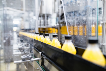 Bottling factory - Orange juice bottling line for processing and bottling juice into bottles. Selective focus. 