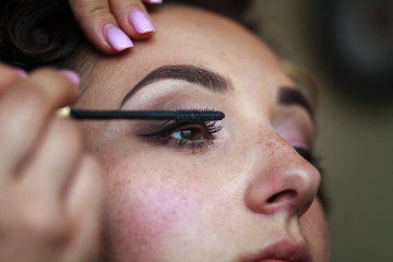 Wedding makeup artist making a make up for bride