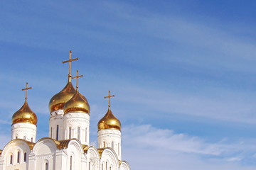 The Golden domes of the Bryansk Cathedral on blue sky background with clouds on a Sunny day