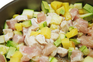 cooking vegetable stew with chicken in a frying pan