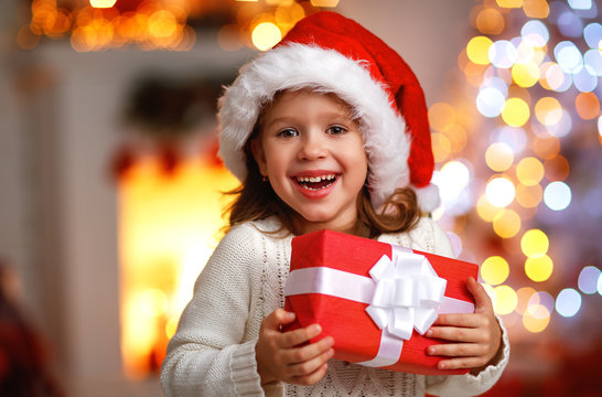 Happy Laughing Child Girl With Christmas Present At Home