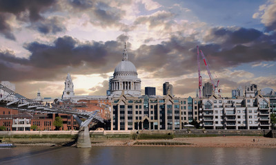 Fototapeta premium View across the river thames in London to St Pauls Cathedral and the millennium (wobbly) bridge with Dramatic cloudy stormy sky