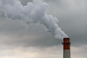 Smoke from the pipe. Against the gray gloomy sky.