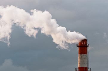 Smoke from the pipe. Against the gray gloomy sky.
