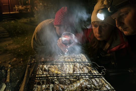 People grilling meat in the backyard, outdoor nightlight shot