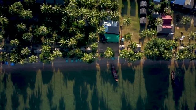 Looking straight down at the backpacker tourist accommodations on the beach, the camera moves to the left slowly.