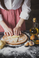 Obraz na płótnie Canvas Making dough by female hands at bakery
