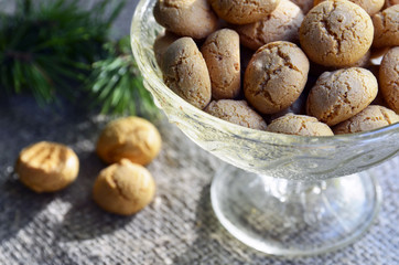 Italian Christmas cookies amaretti in a white heart shaped bowl.Tasty Italian amaretti biscuits on old wooden table.Amarettini cookies.Selective focus.