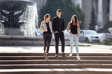 Three friends walk on the street