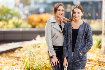 Two girls sit on the bench and lauch to camera