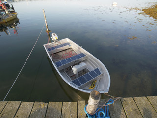 Dinghys moled to wooden pier, with clear water