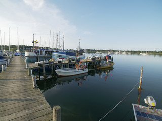 Fototapeta premium wooden pier, with sailboats and dinghys with blue sky in the summer