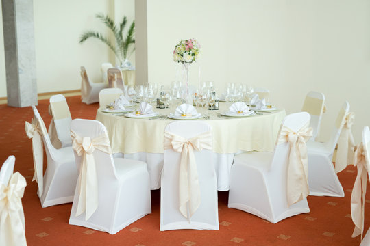 Beautiful wedding floral decoration on a table in a restaurant.White tablecloths, bright room.