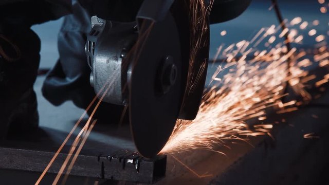 Angle grinder cutting through metal and producing a lot of sparks.