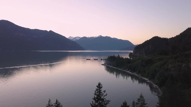 Aerial 4k drone footage of Howe Sound during a vibrant and colorful summer sunset. Taken North of Vancouver, British Columbia, Canada.
