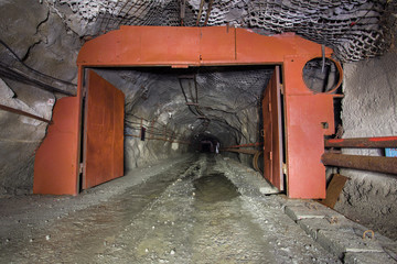 Steel gate in the underground ore mine shaft tunnel