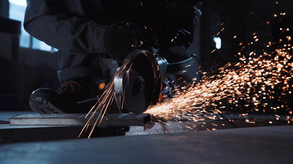 Angle grinder producing sparks while cutting metal - obrazy, fototapety, plakaty