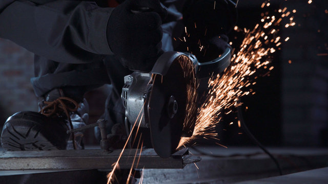 Angle grinder producing sparks while cutting metal