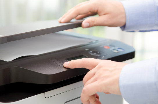 Hand press button on panel of printer