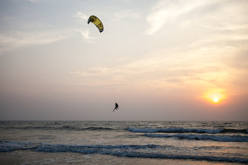 Beautiful ocean sunset, kitesurfer on the waves