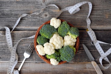 Broccoli and cauliflower on a wooden table 