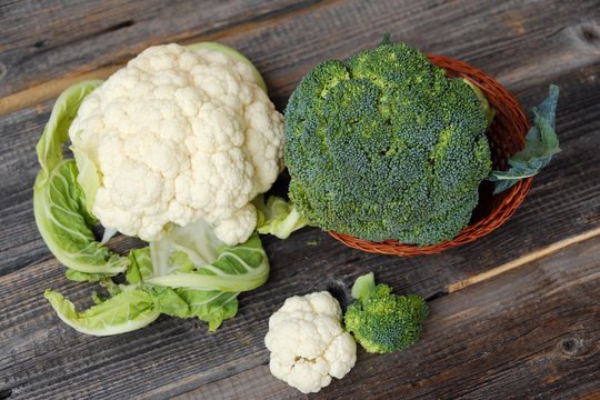 Broccoli and cauliflower on a wooden table 