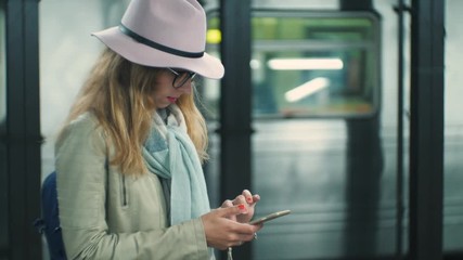 Woman looking at her mobile phone in metro station in New York City