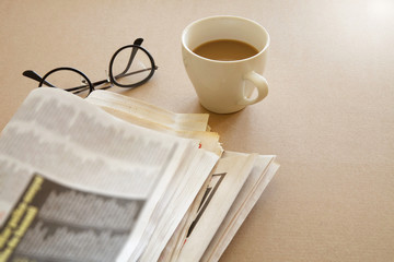 Newspaper with coffee on brown background