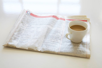 Newspaper with coffee on table