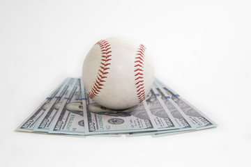 Baseball sits atop a pile of money